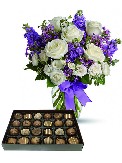 Rose bianche e fiori viola con cioccolatini